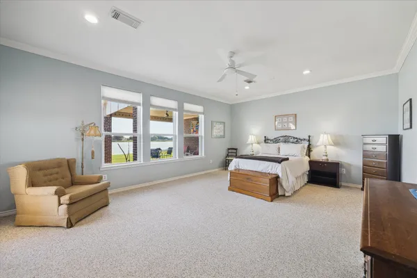 a spacious bedroom with a bed couch and a large window