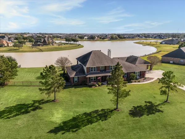 an aerial view of a house with a garden and lake view