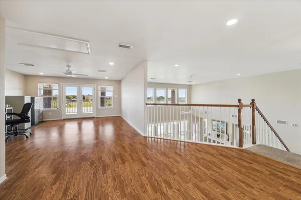 a view of a hallway with wooden floor and windows