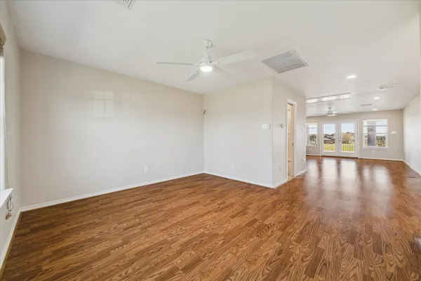 a view of empty room with wooden floor