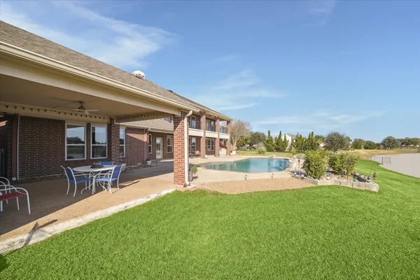 a view of a house with a big yard and sitting area