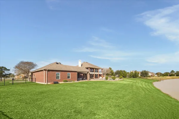 a view of a big house with a big yard and large trees