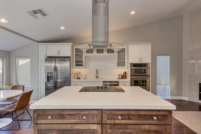 a kitchen with stainless steel appliances kitchen island a refrigerator sink and stove