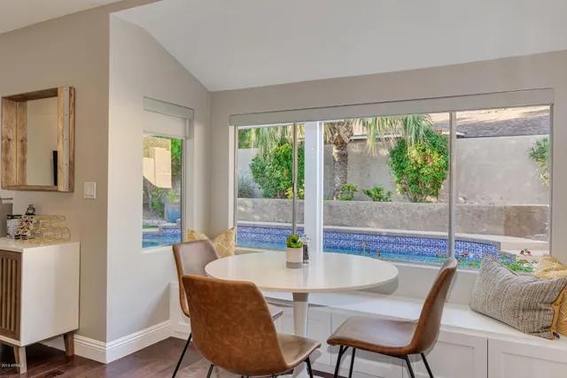 a dining room with furniture water view and a floor to ceiling window