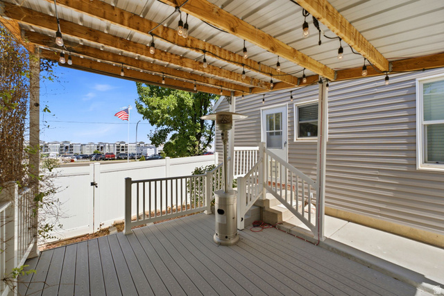 1925 South Main Street Bountiful, UT 84010 - Photo 36 of 48 Covered outdoor deck featuring composite decking, white railings, and a wood-beamed ceiling with string lighting