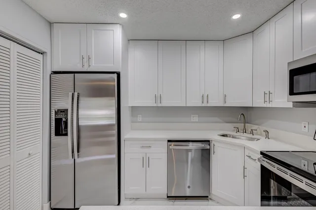 a kitchen with cabinets appliances and a sink