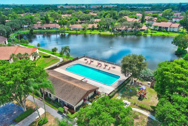 an aerial view of a house with a garden and lake view