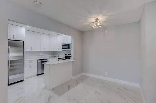 a kitchen with a refrigerator sink and cabinets