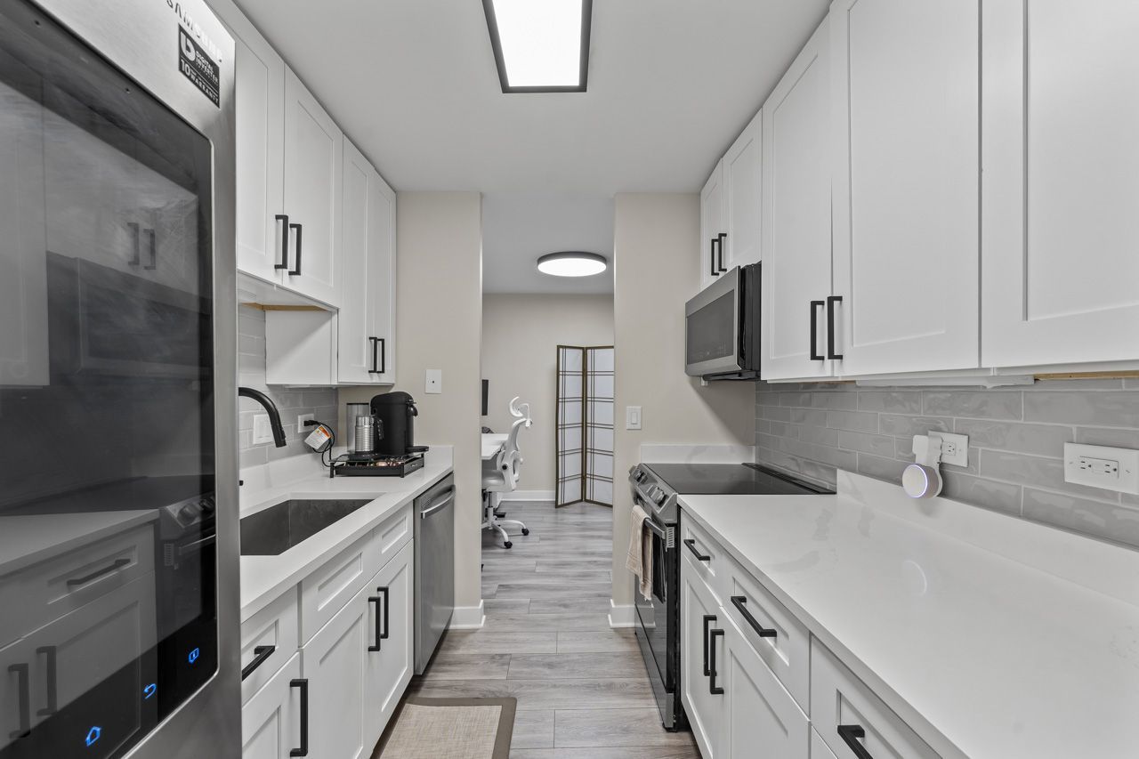 111 East Chestnut Street, Unit 28J Chicago, IL 60611 - Photo 16 of 36 a kitchen that has a lot of cabinets in it and wooden floors