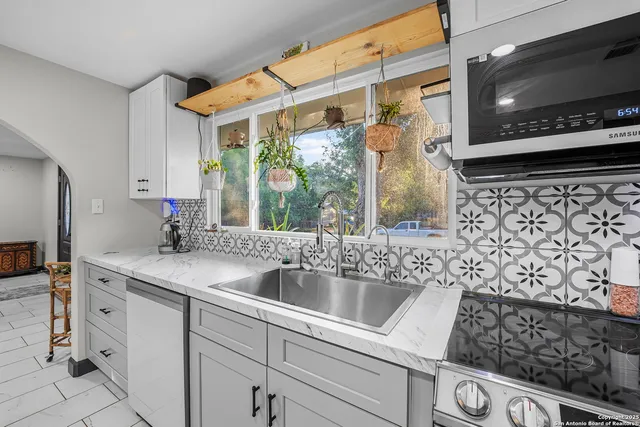 a kitchen with a sink and a stove top oven