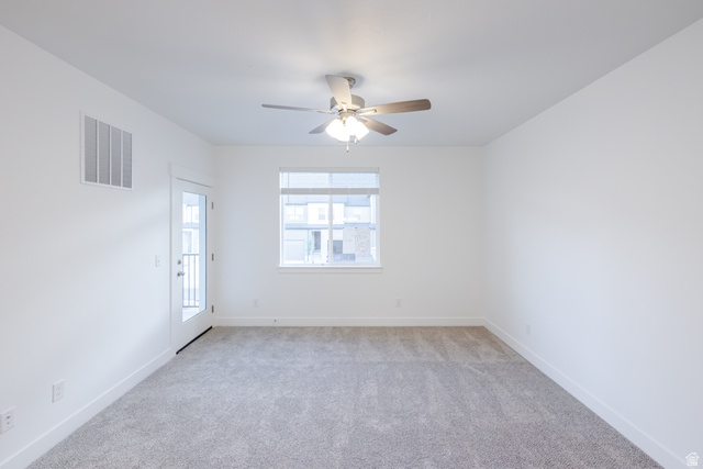 4704 Olive Avenue, Unit V202 Mapleton, UT 84664 - Photo 16 of 17 Spacious room with plush gray carpeting, white walls, a ceiling fan with integrated lighting, a window, and a glass-paneled door