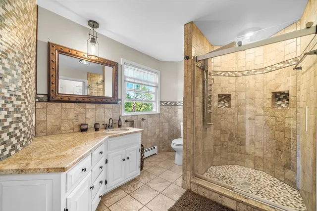 a bathroom with a granite countertop sink mirror vanity and toilet