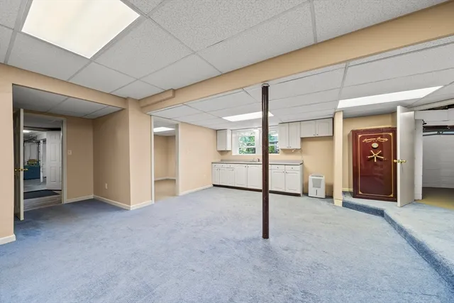 an empty room with white cabinet and mirrors