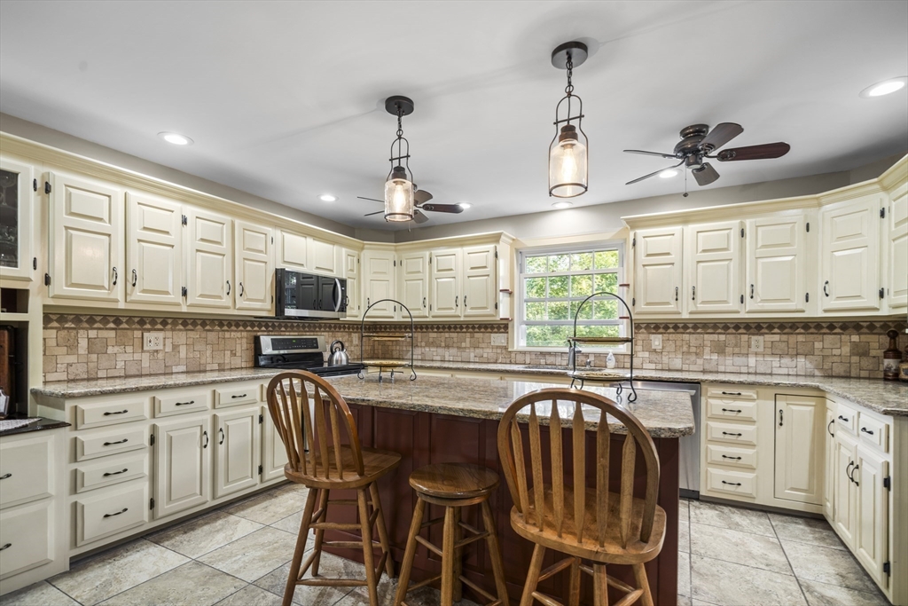 235 James Street Ludlow, MA 01056 - Photo 3 of 41 a kitchen with stainless steel appliances granite countertop a stove a sink a microwave oven a refrigerator with white cabinets and wooden floor