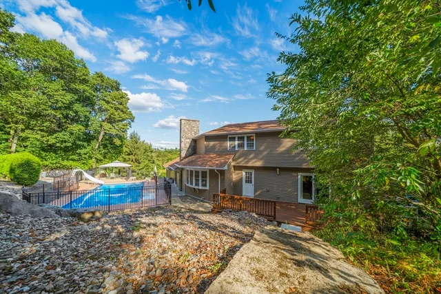 a front view of house with yard and trees in the background