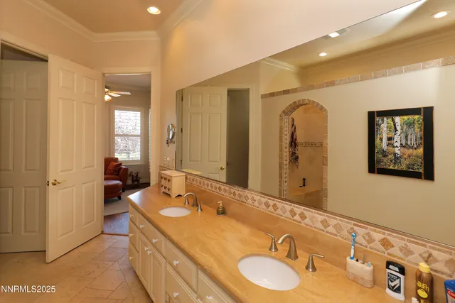 a bathroom with a granite countertop double vanity sink and a mirror