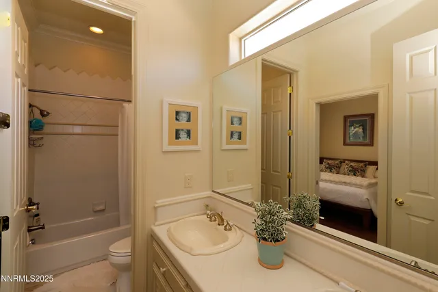 a bathroom with a granite countertop sink a toilet and shower
