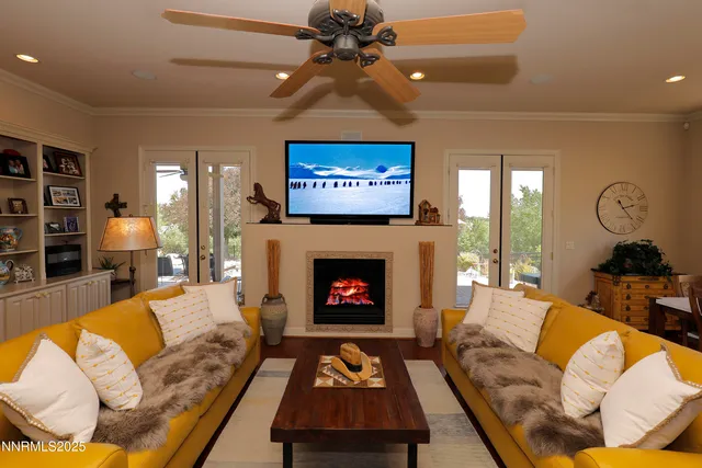 a living room with furniture a fireplace and a ceiling fan