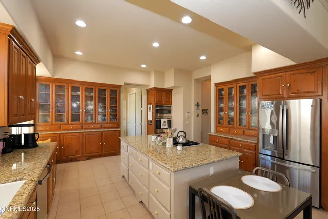 a kitchen with stainless steel appliances granite countertop a sink refrigerator and cabinets
