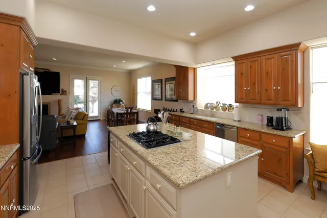 a kitchen with granite countertop kitchen island stainless steel appliances a stove a sink a refrigerator and a center island