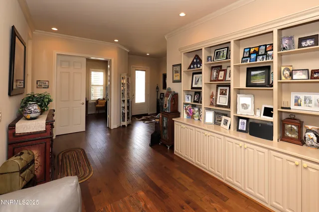 a living room with stainless steel appliances lots of furniture and wooden floors