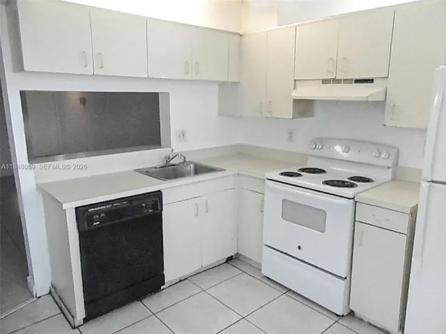 a kitchen with white cabinets and white appliances