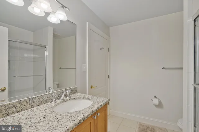 a bathroom with a granite countertop sink a mirror and a shower