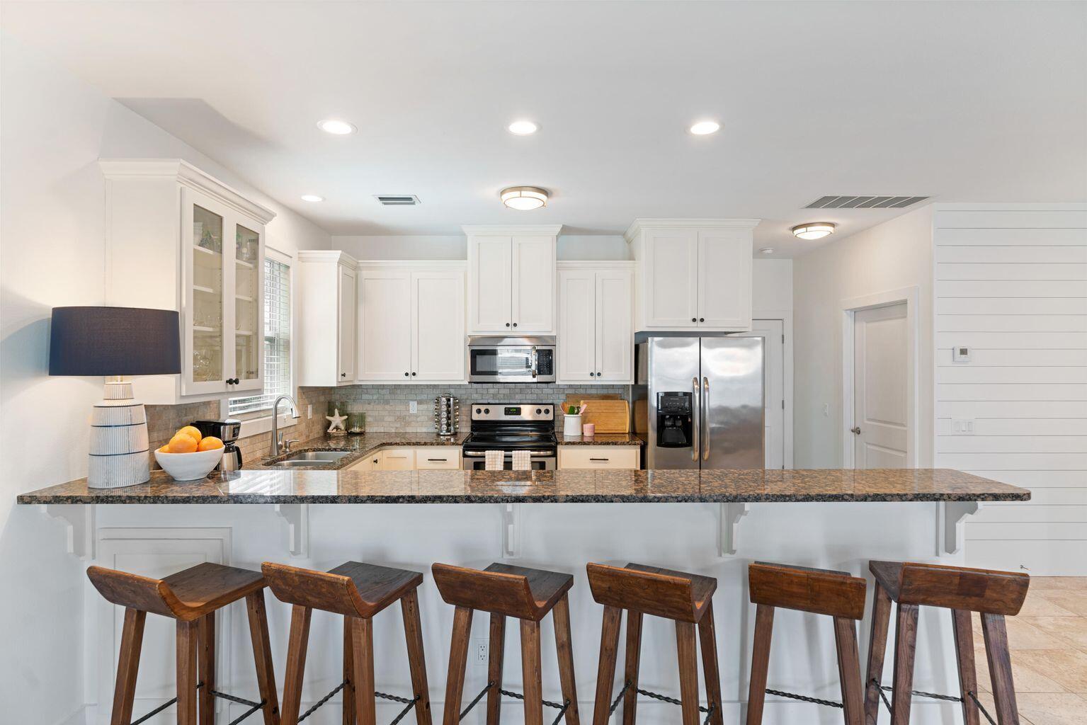 83 Brown Street Santa Rosa Beach, FL 32459 - Photo 5 of 42 a kitchen with granite countertop a sink chairs and cabinets