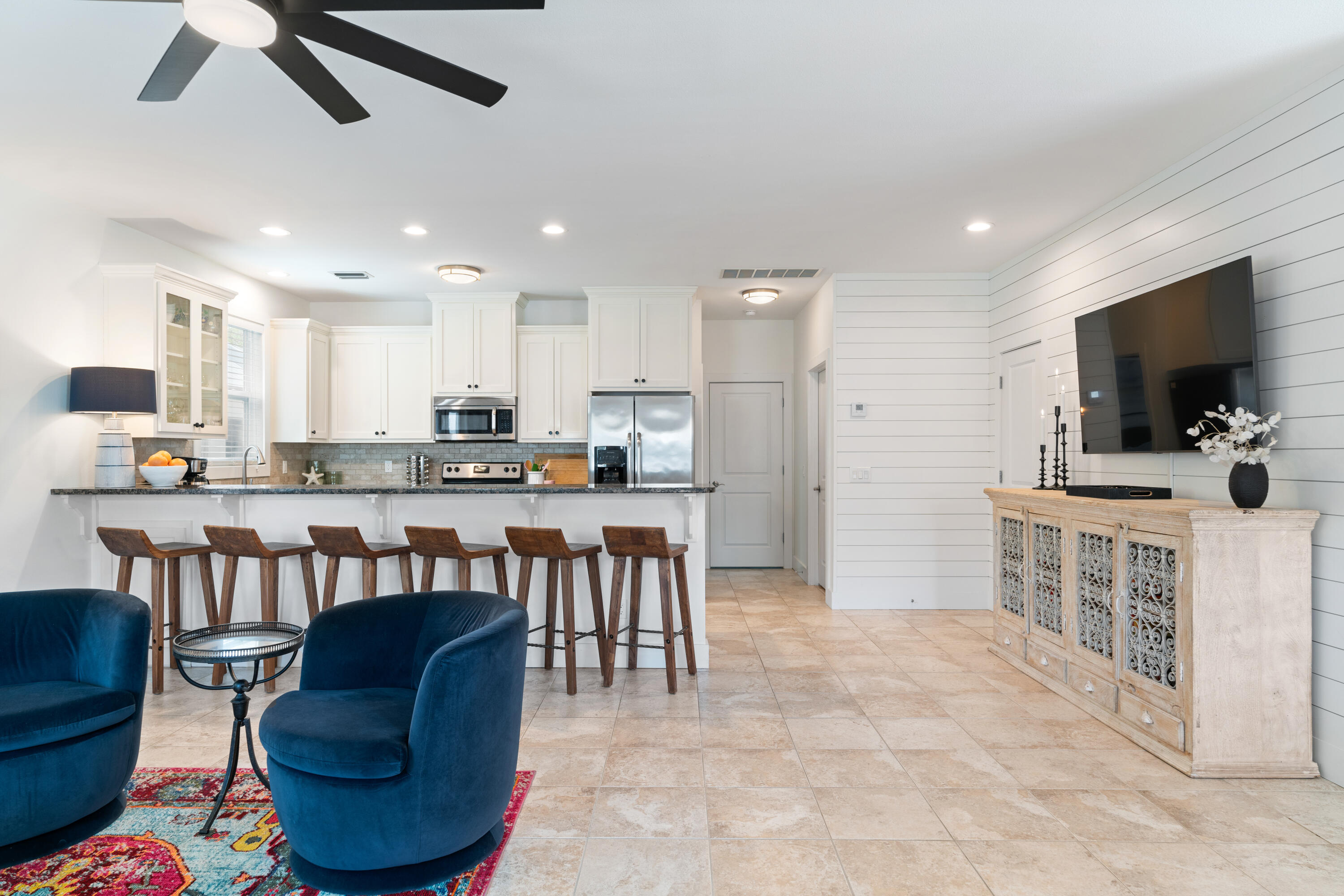 83 Brown Street Santa Rosa Beach, FL 32459 - Photo 10 of 42 a kitchen with stainless steel appliances kitchen island granite countertop a refrigerator a stove a sink a dining table and chairs with wooden floor