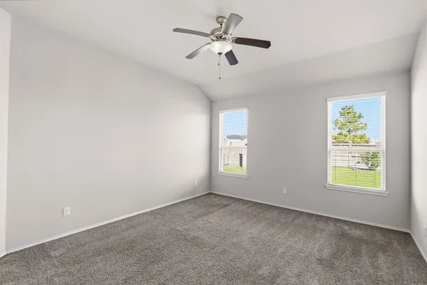 an empty room with windows and fan