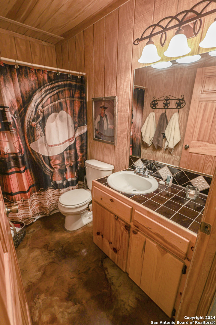 1177 River Road Concan, TX 78838 - Photo 21 of 34 a bathroom with a sink mirror vanity and toilet