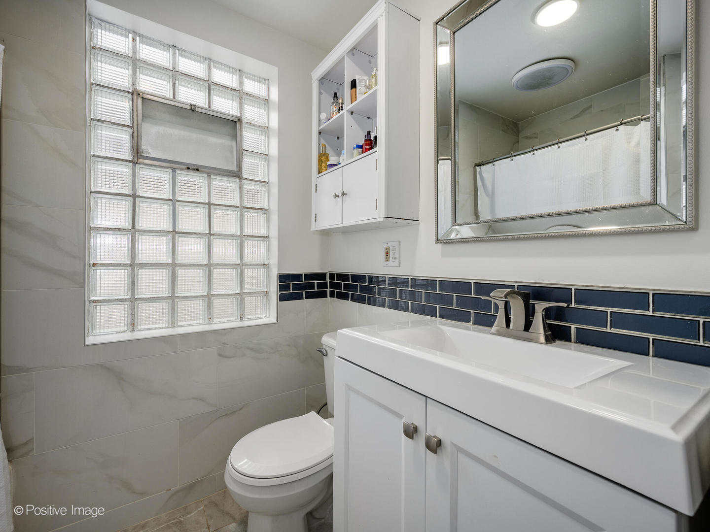 3742 Clinton Avenue Berwyn, IL 60402 - Photo 9 of 28 a bathroom with a sink a toilet and a mirror