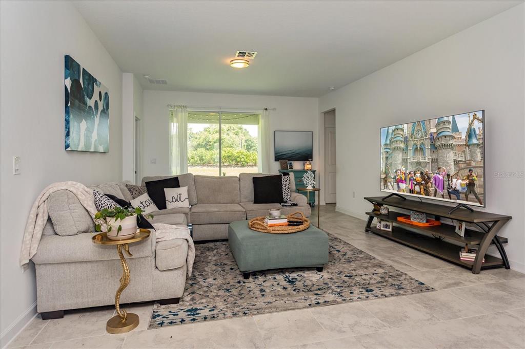 5616 Quiet Palm Loop St. Cloud, FL 34771 - Photo 11 of 25 a living room with furniture and a flat screen tv