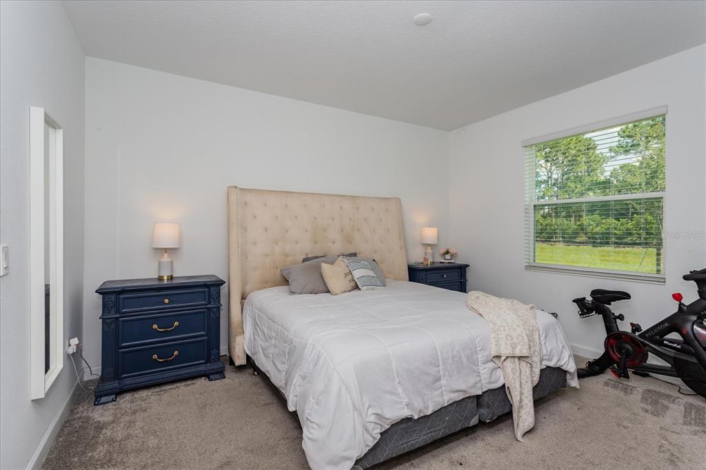 5616 Quiet Palm Loop St. Cloud, FL 34771 - Photo 14 of 25 a bedroom with a bed and a lamp on dresser