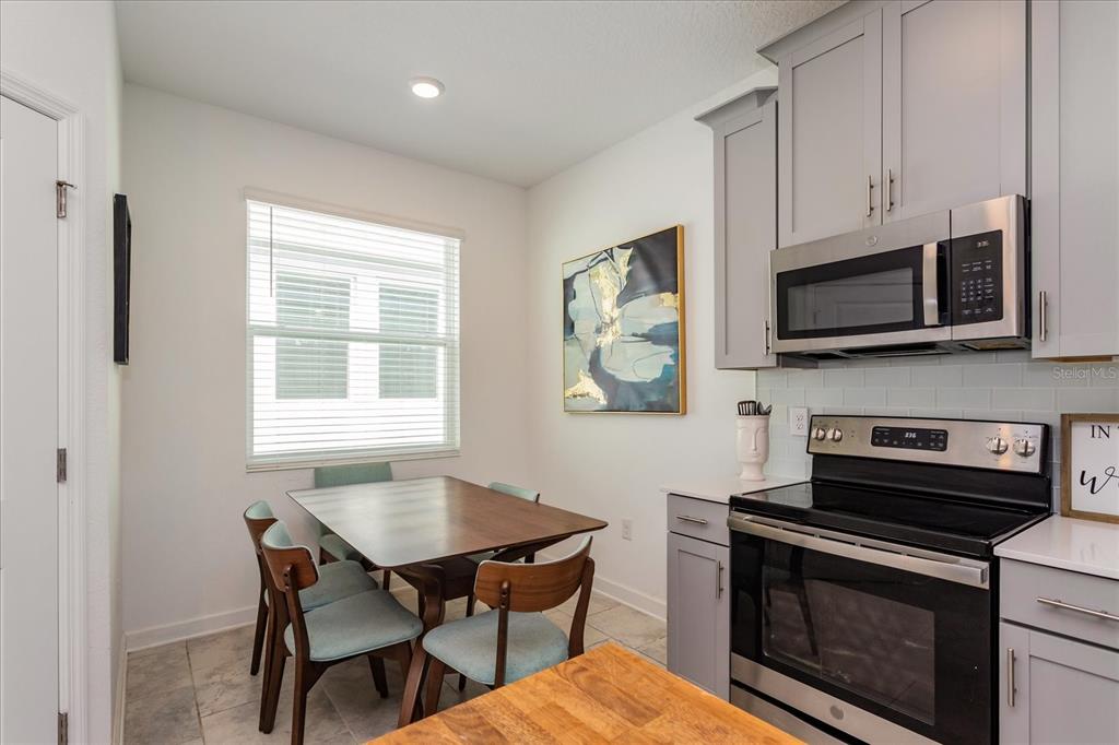 5616 Quiet Palm Loop St. Cloud, FL 34771 - Photo 8 of 25 a kitchen with stainless steel appliances a stove a microwave sink and cabinets