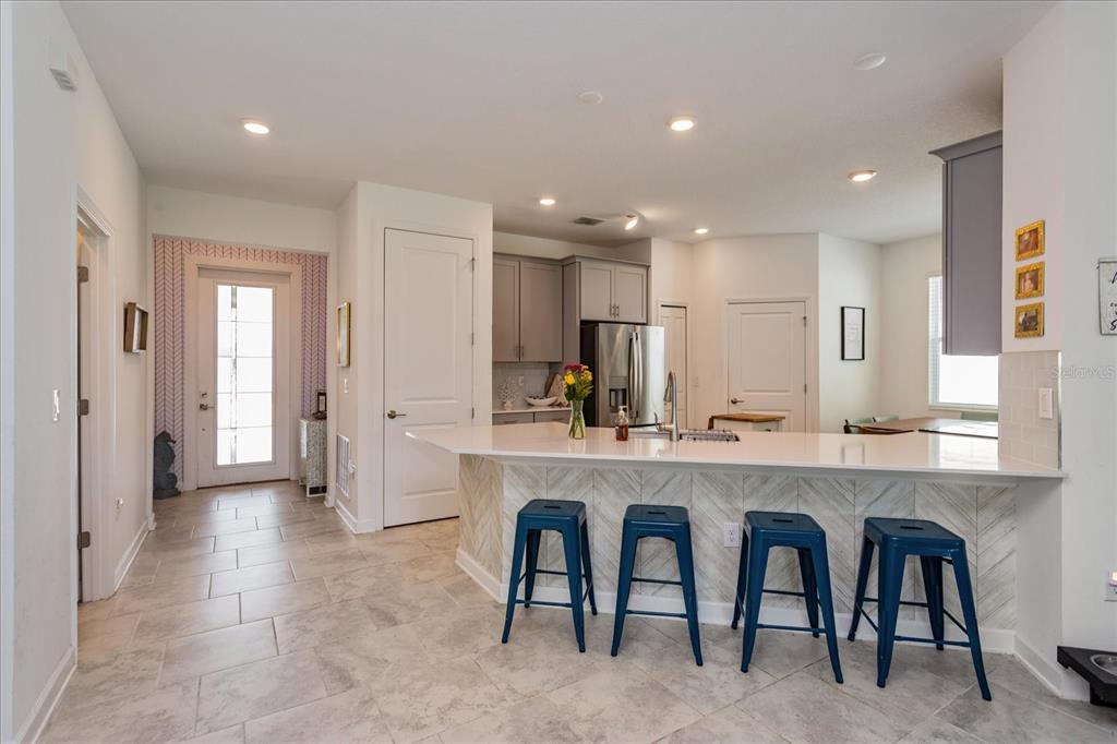 5616 Quiet Palm Loop St. Cloud, FL 34771 - Photo 10 of 25 a large white kitchen with center island and stainless steel appliances