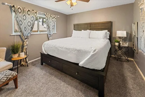 a bed sitting in a bedroom next to a window and a chandelier