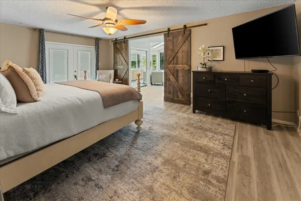 a spacious bedroom with a bed and a flat screen television
