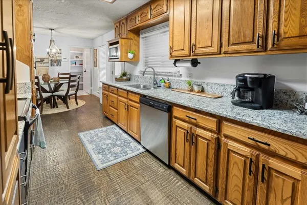 a kitchen with stainless steel appliances granite countertop a sink dishwasher stove and cabinets
