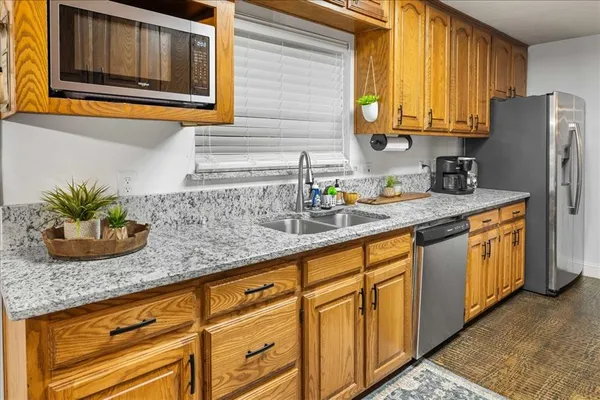 a kitchen with stainless steel appliances granite countertop a sink a refrigerator and a granite counter tops
