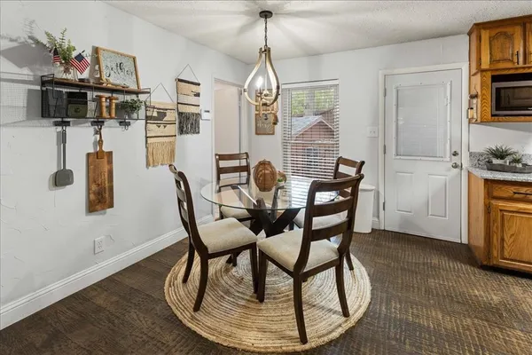 a dining room with furniture a chandelier and wooden floor