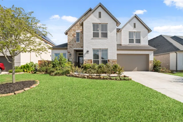 a front view of a house with a yard and garage