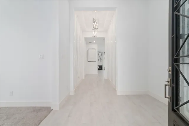 a view of a hallway with wooden floor and entryway