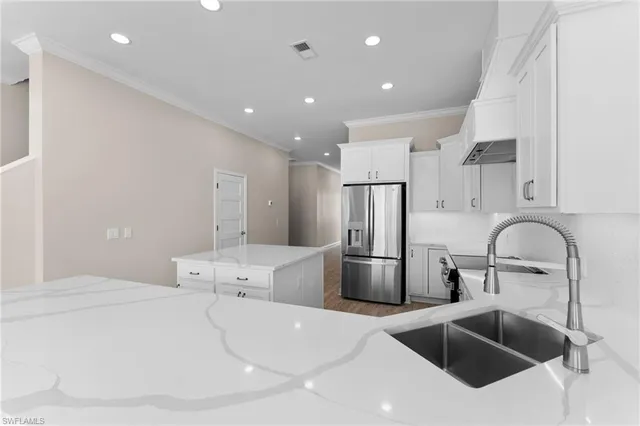 a kitchen with stainless steel appliances a sink a refrigerator and microwave