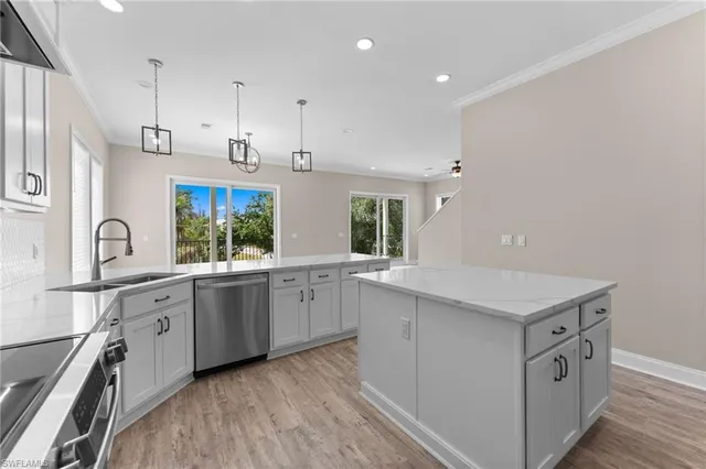 a kitchen with granite countertop cabinets stainless steel appliances a sink and a large window