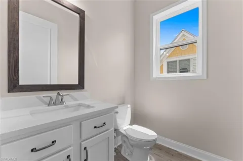 a bathroom with a granite countertop toilet sink and mirror