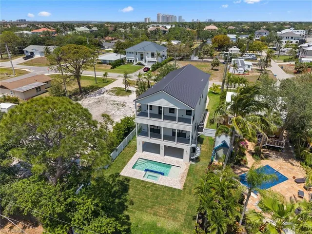 an aerial view of residential houses with outdoor space and trees