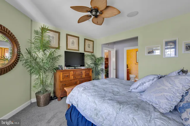 a bedroom with a bed and a flat tv screen on dresser