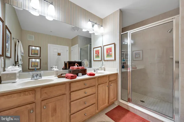 a bathroom with a double vanity sink mirror and shower