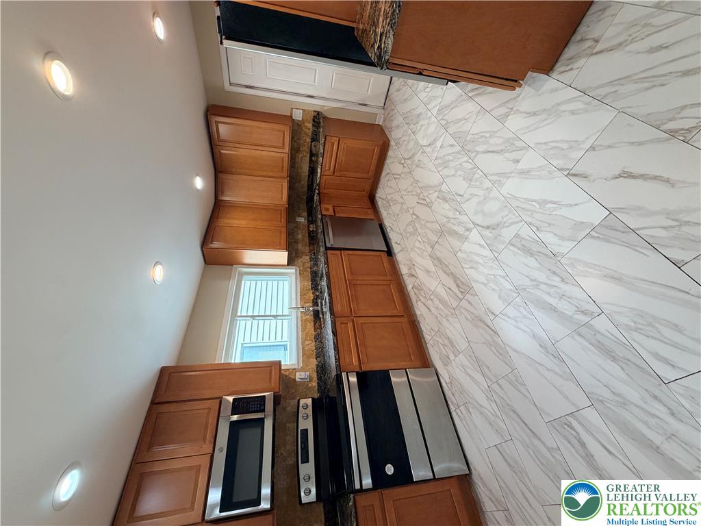 718 Ferry Street Easton, PA 18042 - Photo 7 of 37 A well-appointed kitchen features warm cabinetry, granite countertops, and modern stainless steel appliances.
